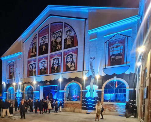 Teatro o edificio storico illuminato con luci scenografiche blu per evento aziendale serale – Osmosis Synergy, organizzazione eventi a Milano