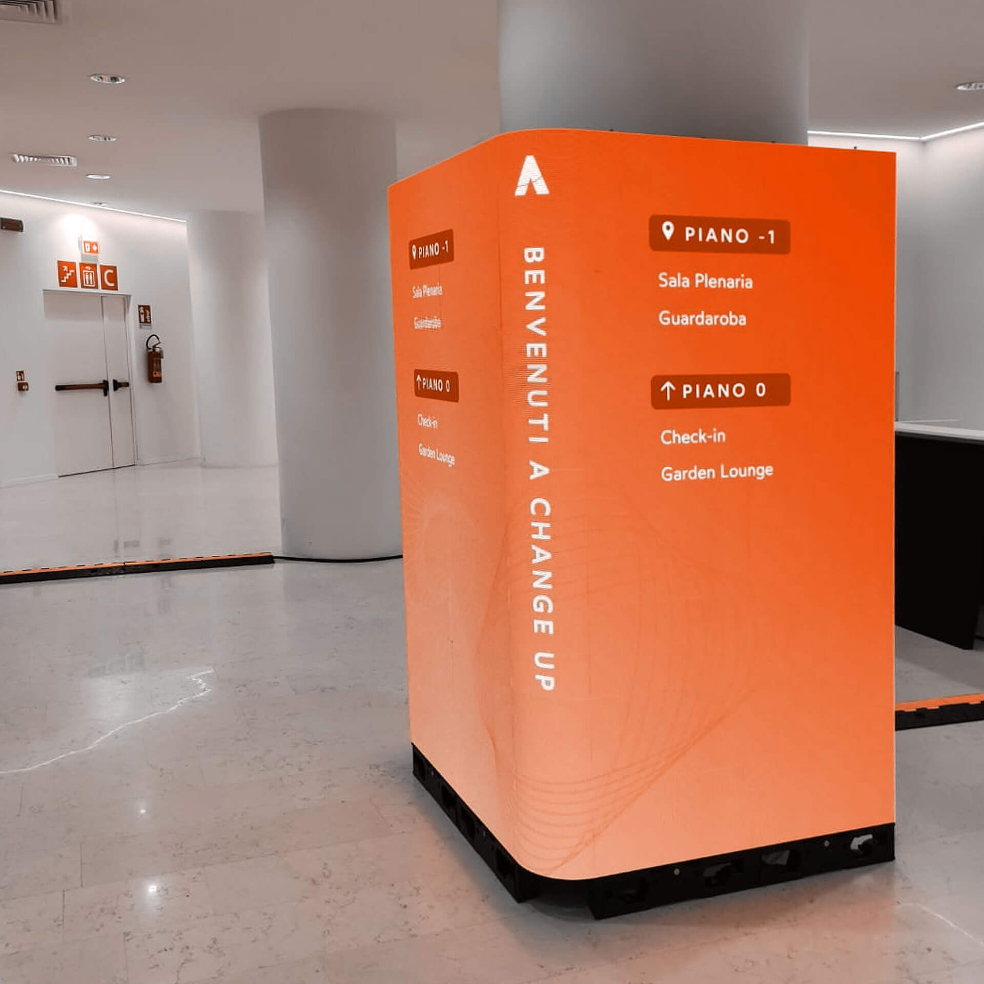 Totem interattivo arancione con display touch per grafica e comunicazione aziendale – Osmosis Synergy Milano