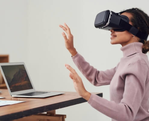 La gamification in azienda: crescere giocando, senza sembrare formazione 7 gamification aziendale e formazione – donna con visore VR in ambiente aziendale Osmosis